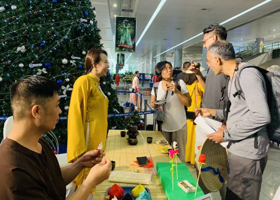 Du khách tìm hiểu các sản phẩm tò he tại gian hàng ở sân bay Tân Sơn Nhất, sáng 1-1-2023